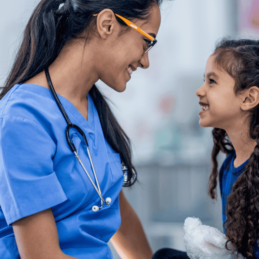 Woman nurse smiling with young girl patient.