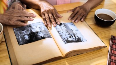 Two people looking at an open photo book on a table.