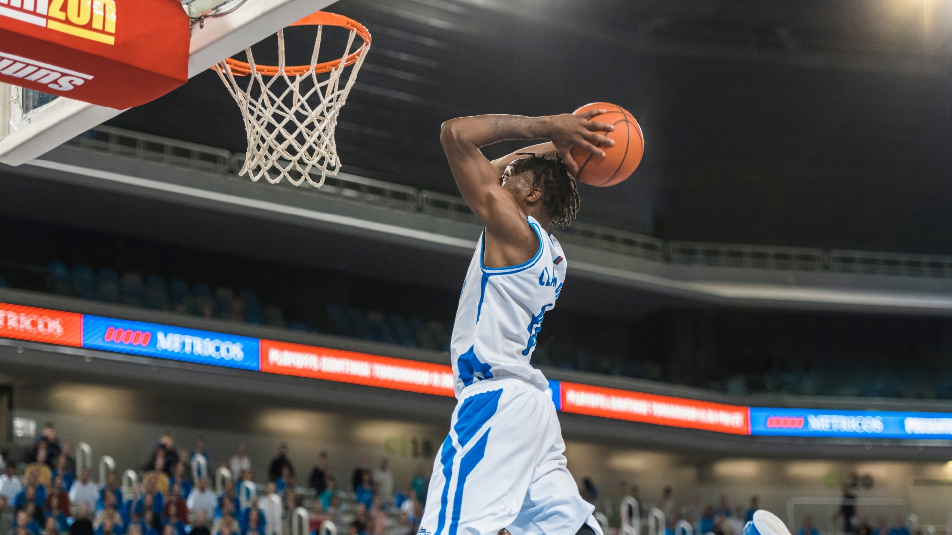 A basketball player dunking the ball.