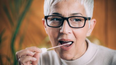 A person with a cotton swab in their mouth.