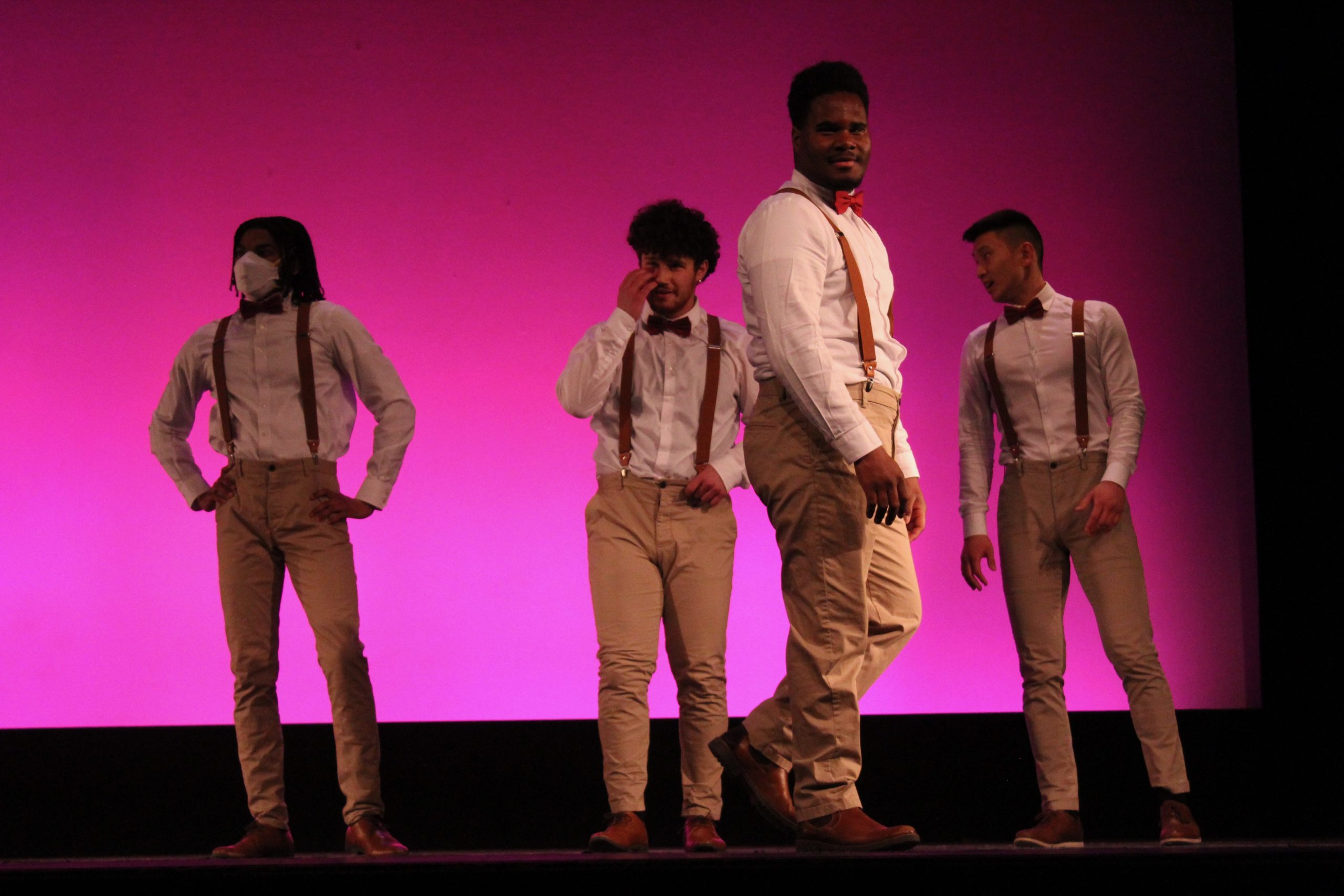 Trey standing on stage with his dance team.
